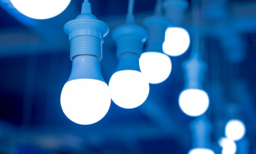 A blue background with bright lightbulbs in the foreground.
